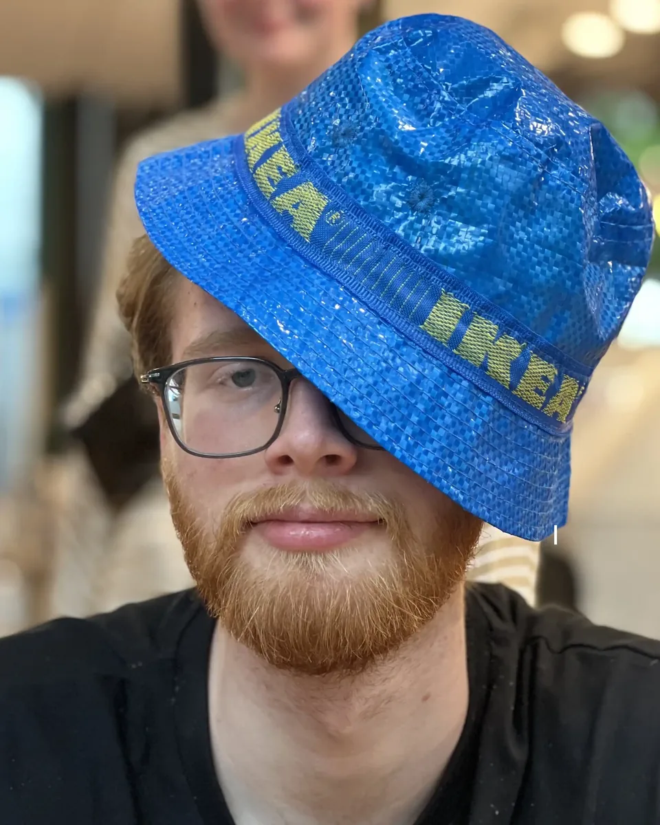 Oleg wearing a blue IKEA bucket hat that covers one eye